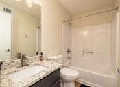Thumbnail 4 of 14 - A white bathroom with a sink, toilet, and bathtub at Overlook Club Apartments, Georgia 30040