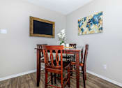 Thumbnail 8 of 16 - a dining room table with chairs and a painting on the wall at The Davis Apartments, Huntsville, AL 35816  