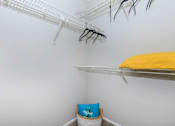 Thumbnail 16 of 16 - a closet with shelves and a yellow bed in it and a white wall with shelves at The Davis Apartments, Huntsville, AL  