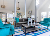 Thumbnail 9 of 16 - a living room with blue chairs and a gray couch at The Davis Apartments, Huntsville, AL  