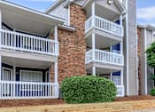 Thumbnail 1 of 16 - a building with two balconies and a bush in front of it at The Davis Apartments, Huntsville, AL 35816  