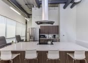 Thumbnail 16 of 57 - a kitchen with a large island with chairs around it at Jefferson Yards, Tacoma, 98402