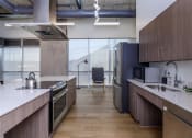 Thumbnail 15 of 57 - a kitchen with a stove top oven next to a sink at Jefferson Yards, Tacoma, WA