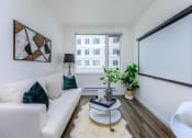 Thumbnail 8 of 57 - a living room with a white couch and a large window at Jefferson Yards, Tacoma, WA