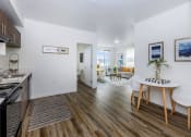 Thumbnail 48 of 57 - a kitchen and living room with wood floors and white walls at Jefferson Yards, Washington, 98402