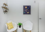 Thumbnail 33 of 57 - a living room with two white chairs and a small table with a plant on top of it at Jefferson Yards, Washington