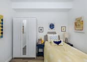 Thumbnail 32 of 57 - a bedroom with white walls and a yellow bedspread at Jefferson Yards, Tacoma