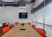 Thumbnail 17 of 57 - a conference room with a long table and orange chairs at Jefferson Yards, Tacoma Washington