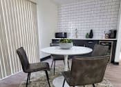 Thumbnail 2 of 22 - A dining room with a white table and chairs.