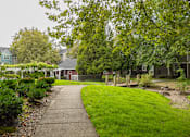 Thumbnail 40 of 48 - A walkway leads through a grassy area to a building.