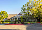 Thumbnail 2 of 48 - A building with a red X on the roof is surrounded by trees and bushes.
