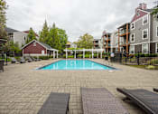 Thumbnail 38 of 48 - A pool surrounded by a black fence and a red barn.