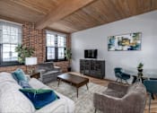 Thumbnail 13 of 27 - A living room with a grey couch and a wooden ceiling.
