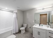 Thumbnail 14 of 27 - A white bathroom with a toilet, sink, and bathtub.