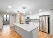 Thumbnail 26 of 27 - A modern kitchen with a white countertop and stainless steel appliances.
