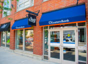 Thumbnail 6 of 10 - a brick building with a blue awning and two glass doors with a sign that reads