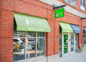 Thumbnail 10 of 10 - a brick building with a green awning and a sign that says back to life wellness