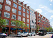 Thumbnail 1 of 10 - a large brick building with cars parked in front of it