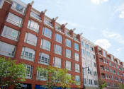 Thumbnail 3 of 10 - a red brick building with many windows and trees in front of it
