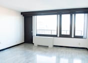 Thumbnail 18 of 21 - A large empty room with a window seat and a door.