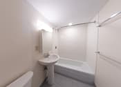 Thumbnail 17 of 21 - A white bathroom with a sink, toilet, and bathtub.