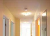 Thumbnail 13 of 17 - a hallway with white walls and wood floors