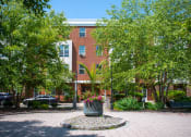 Thumbnail 8 of 17 - a large brick building with a large planter in front of it