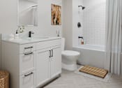Thumbnail 5 of 27 - A white bathroom with a sink, toilet, and bathtub.