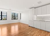 Thumbnail 32 of 33 - A room with white cabinets and wooden flooring.