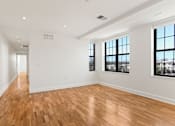 Thumbnail 31 of 33 - A large empty room with wooden floors and white walls.