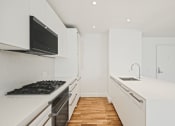 Thumbnail 17 of 33 - a kitchen with white cabinets and a stove