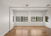 Thumbnail 28 of 33 - the living room of an apartment with white walls and wood floors