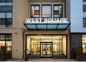 Thumbnail 1 of 6 - a large building with a sign that says west square on top of it