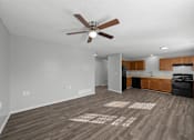 Thumbnail 1 of 17 - A spacious room with a ceiling fan and wooden flooring.