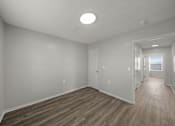 Thumbnail 5 of 17 - A room with wooden flooring and white walls.