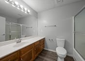 Thumbnail 3 of 17 - A white toilet sits next to a sink in a bathroom.