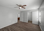 Thumbnail 2 of 17 - A room with a ceiling fan and wood flooring.