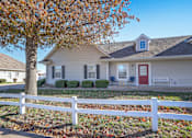 Thumbnail 14 of 17 - A house with a red door and a white fence.