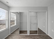 Thumbnail 4 of 17 - A room with a walk-in closet and a window with blinds.
