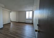 Thumbnail 11 of 21 - an empty living room with wood floors and a window