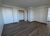 Thumbnail 7 of 21 - an empty living room with wood floors and white walls