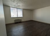 Thumbnail 12 of 21 - an empty living room with wood floors and a window