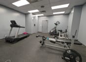 Thumbnail 16 of 21 - a gym with exercise equipment and weights in a building
