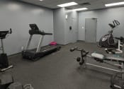 Thumbnail 6 of 21 - a gym with exercise equipment on the floor and a door