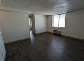 Thumbnail 20 of 21 - an empty living room with wooden floors and a window