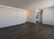 Thumbnail 19 of 21 - an empty living room with wood floors and white walls