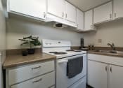 Thumbnail 13 of 21 - an empty kitchen with white appliances and white cabinets