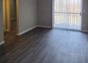 Thumbnail 13 of 16 - an empty living room with wooden floors and a window