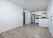 Thumbnail 2 of 6 - an empty living room and kitchen with white walls and wood flooring