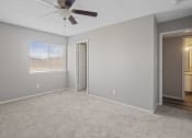 Thumbnail 10 of 25 - an empty living room with a ceiling fan and a window